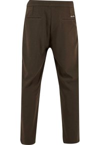 Pantalon tapered marron foncé avec une taille élastique, deux poches arrière et une texture lisse, conçu pour le confort et la liberté de mouvement.
