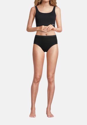 Sport bra in cotone nero con spalline larghe, abbinato a slip neri a vita alta, caratterizzati da una texture liscia e senza motivi o accessori visibili.