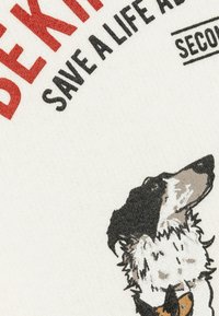 Tejido de algodón que presenta un gráfico de un perro en gris y negro, con texto en rojo y negro que dice "SE AMABLE, SALVA UNA VIDA, ADOPTA."