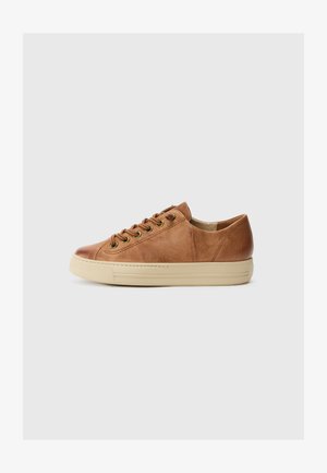 Sneaker en cuir marron avec un bout arrondi, semelle en caoutchouc beige, œillets en métal et lacets plats. La texture semble lisse avec de subtiles variations.