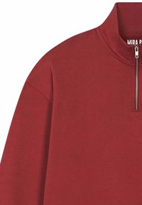 Pull-over bordeaux avec col montant et fermeture éclair courte. Fabriqué en tissu doux avec une texture lisse et une coupe décontractée. Présente un logo discret.