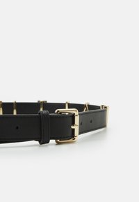 Cinto de couro preto com uma fivela retangular em tom de ouro, textura suave e múltiplos furos para ajustes, com um design elegante.