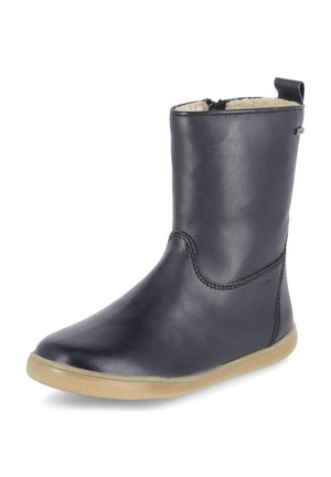 Czarny skórzany but do połowy łydki z beżową podeszwą, zamkiem błyskawicznym z boku, pętelką do ściągania i widoczną u góry jasną podszewką z polaru.