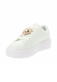 Zapatilla de cuero blanca con punta redonda y una gruesa suela de plataforma blanca. Presenta un acento decorativo dorado con un borde texturizado.