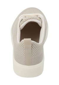 Chaussure de sport beige clair avec une tige en maille texturée, un collier élastique et une semelle en caoutchouc blanc. Anse arrière pour un enfilage facile.