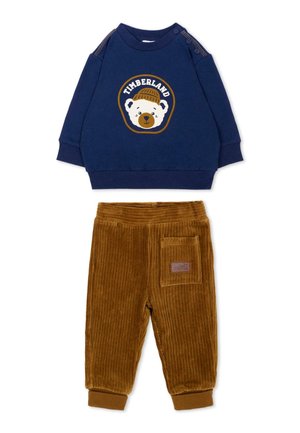 Sweat-shirt bleu marine pour tout-petit avec un ours et le logo Timberland, assorti à un pantalon en velours côtelé marron avec une poche latérale.