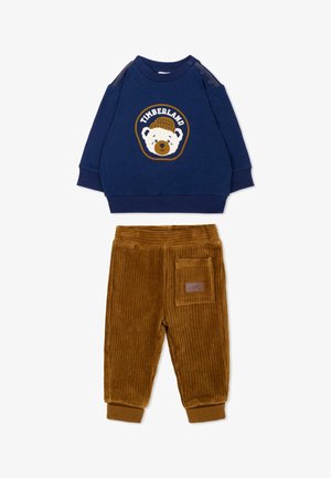 Granatowa bluza dla malucha z niedźwiedziem i logo Timberland, w zestawieniu z brązowymi, prążkowanymi sztruksowymi spodniami z boczną kieszenią.
