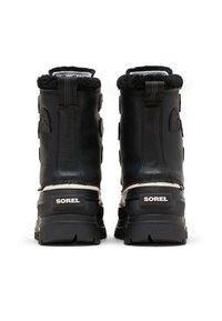 Svarta vinterstövlar i läder med fuskpälskrage, robust gummisula och justerbara remmar. "SOREL"-logotyp synlig på baksidan.