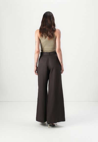 Pantalones de pierna ancha de color marrón oscuro, hechos de una tela ligera con una textura suave; la parte trasera tiene dos bolsillos y una cintura ajustada.