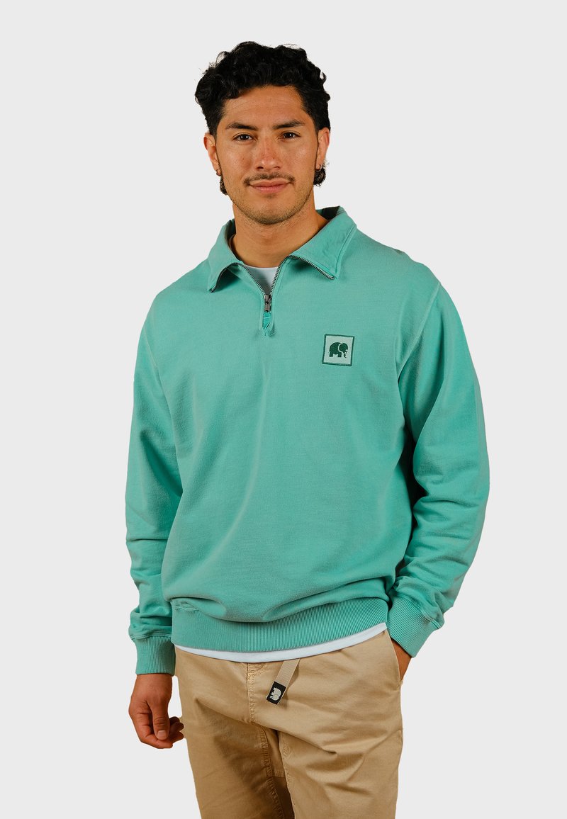 Pullover in pile turchese con colletto zip, dotato di un piccolo logo a forma di elefante sul petto e polsini e orlo a costine.