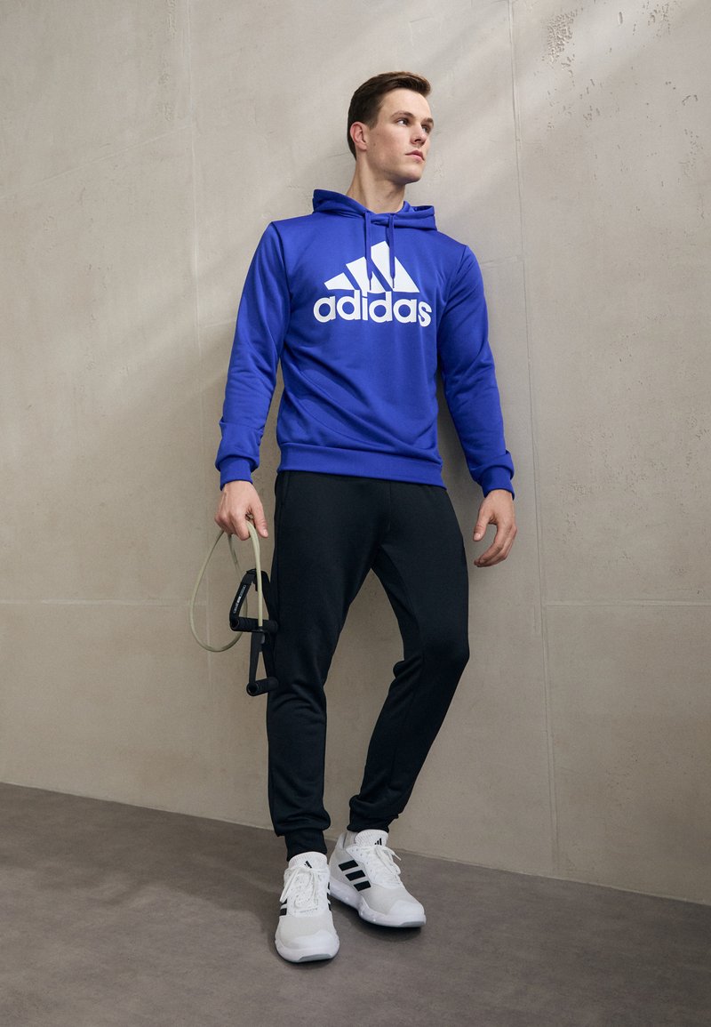 adidas Sportswear SPORTSWEAR HOODED TRACKSUIT SET - Tuta - semi lucid blue/black