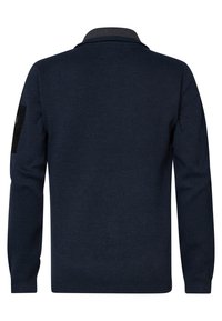 Marineblauer gestrickter Pullover mit langen Ärmeln, solider Textur und einem schwarzen Patch am linken Ärmel. Besitzt einen Kragen mit einem grauen Akzent.