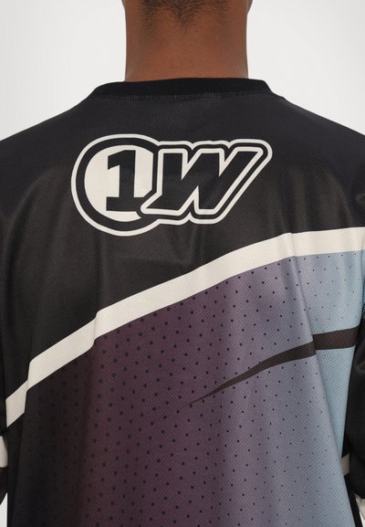 Schwarzes Sporttrikot mit großem weißen Logo, einem Farbverlauf in Lila und Blau, mit Netztextur und kurzen Ärmeln.