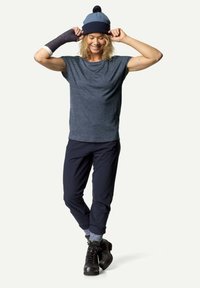 Blå strikket lue med pom-pom, grå t-skjorte med korte ermer, marineblå bukser og svarte støvler. Sokker med et blått mønster ved cuffene.