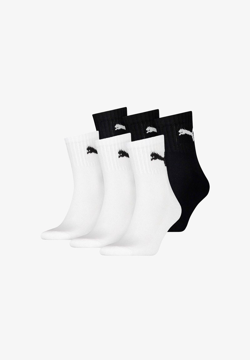 Vier Paare Crew-Socken: zwei weiße mit schwarzen Logos und zwei schwarze mit weißen Logos. Rippbündchen; glatte Textur; sportlicher Stil.