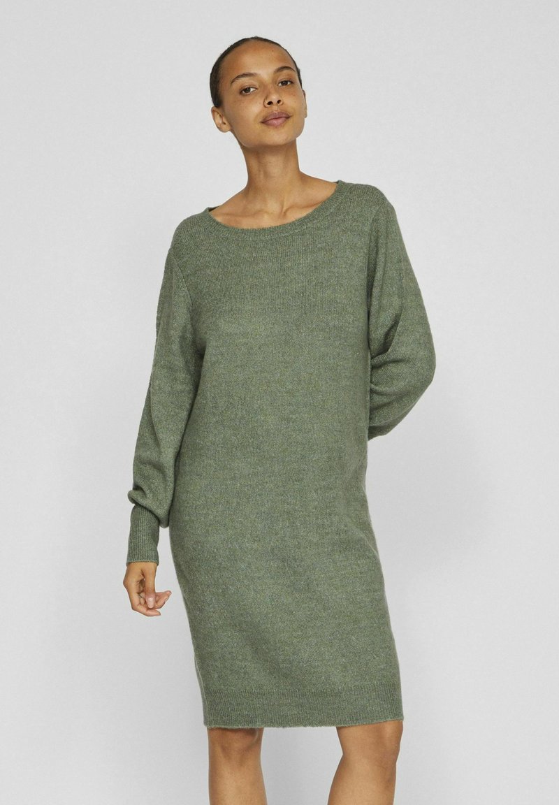 Grünes Strickkleid mit runder Halslinie, langen Ärmeln und gerippten Bündchen. Hat eine weiche Textur und eine lockere Passform.