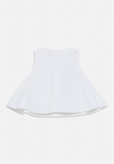 Haut évasé sans manches blanc avec fermeture éclair au dos et encolure ronde, posé à plat sur un fond uni.