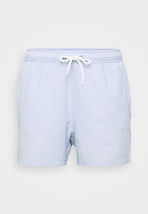 Vaaleansiniset uimapuvut, joissa on ruudullinen kuvio, joustava vyötärö ja valkoinen nyöri. Kangas on sileä, mutta siinä on hienoinen tekstuuri.