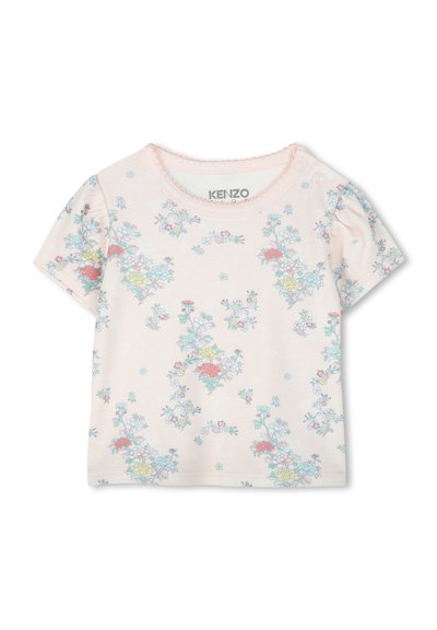 T-shirt rose clair à manches courtes en coton doux, avec un imprimé floral comprenant des fleurs bleues, rouges et jaunes. Encolure festonnée, style à enfiler.