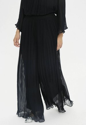Schwarze, plissierte, weit geschnittene Hosen aus leichtem Stoff, mit hohem Bund und transparenter Textur, die einen fließenden Bewegungsstil bieten.