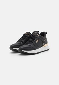 Baskets de sport noires avec un dessus en cuir lisse, accents dorés et semelle intermédiaire blanche ; elles disposent de lacets noirs et d'un talon texturé.