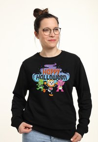 Felpa nera con una grafica colorata di Halloween che mostra orsi cartoni animati vestiti in costumi. Il testo dice "Buon Halloween."