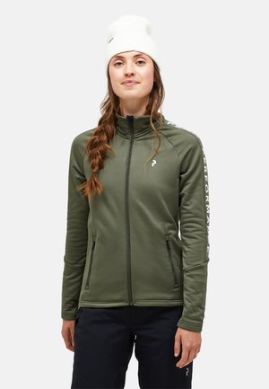Olijfgroene zip-up jas met hoge kraag, twee voorzakken en witte tekst op de mouwen. Zachte, gladde textuur, getailleerd ontwerp. Witte beanie.