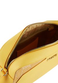 Borsa a tracolla gialla in materiale sintetico con una texture liscia e una chiusura con zip. All'interno presenta una fodera a motivo e una tasca per carte.