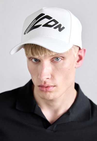 Cappellino da baseball bianco con un design logo nero sulla parte anteriore. Realizzato in tessuto; presenta una visiera e una corona strutturata.