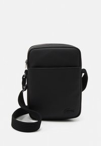 Fekete, téglalap alakú, szövetből készült keresztpántos táska, elülső zsebbel, fém cipzárral és állítható pánttal.
