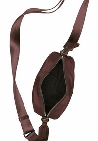 Petit sac bandoulière marron avec une large sangle ajustable et une fermeture éclair ouverte révélant une doublure intérieure noire.