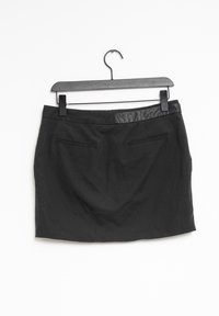Černá sukně vyrobená z látky s hladkou strukturou. Má koženkový pás, dvě přední kapsy a rovný střih.