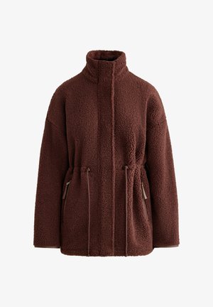 Barna bolyhos dzseki magas gallérral, elülső cipzáras záródással, húzózsinórral a derékrészen és cipzáras zsebekkel mindkét oldalon.