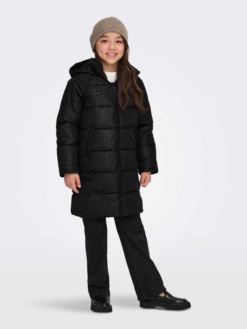 Puffer coat in black with a crocodile texture, featuring a hood and full-length zipper. Paired with black pants and shiny shoes.