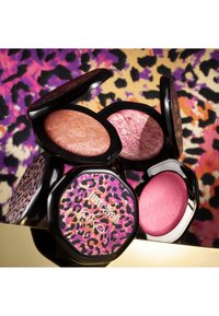 Compacte blushes in zwarte luipaardprint-etuis, met roze, perzik- en gemarmerde tinten op een levendige dierenprintachtergrond.