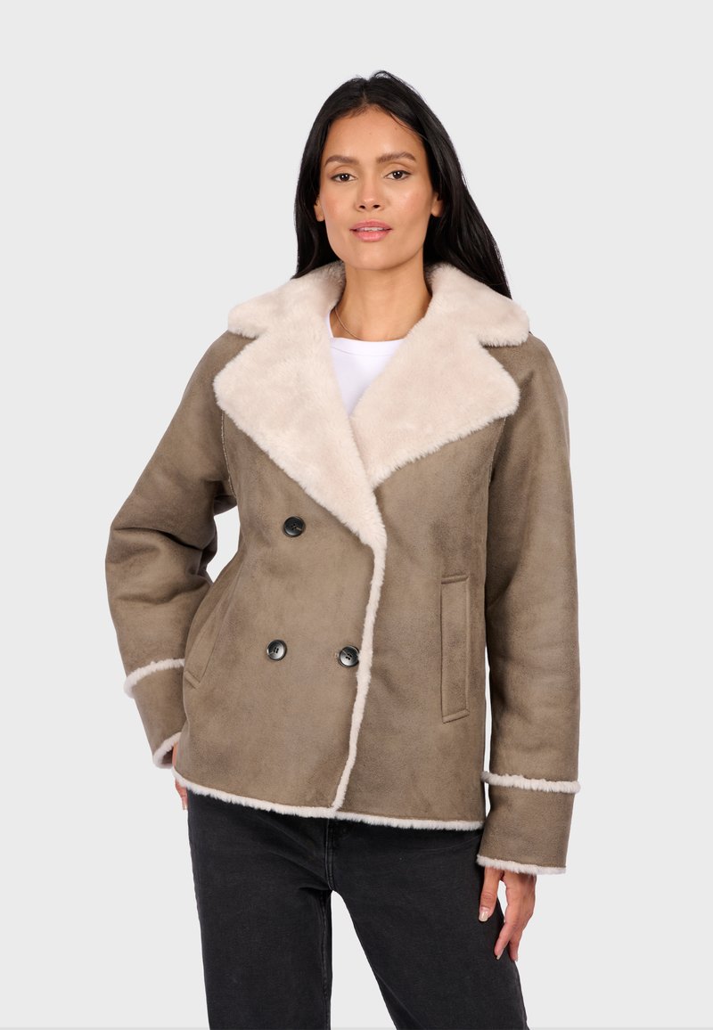Braune doppelte Jacke mit cremefarbenem Kunstfellkragen und -besatz, die zwei vordere Taschen und schwarze Knöpfe aufweist. Weicher Textur, maßgeschneiderte Design.