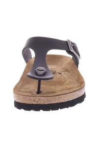 Zwarte leren teensandalen met kurken voetbed, gestructureerd oppervlak, verstelbare gesp en rubberen zool. Voorzien van een metalen studdetail.