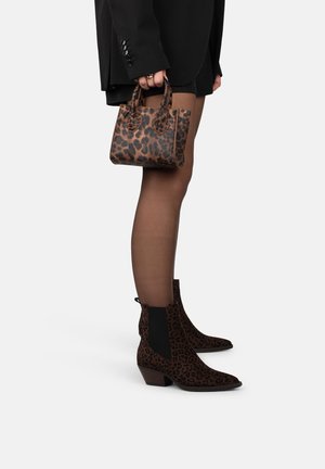 Stivaletti alla caviglia con stampa leopardata, tacco basso e pannelli laterali elastici neri, abbinati a una borsa a tracolla con stampa leopardata coordinata.