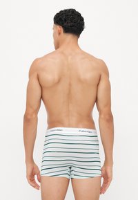 Heren boxershorts in wit met groene horizontale strepen. De elastische tailleband heeft het "Calvin Klein" logo in het zwart. Zachte, rekbare stof.