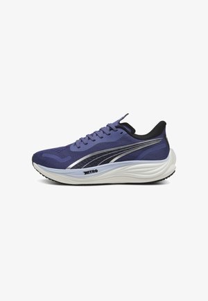 Scarpa sportiva viola con tomaia in rete testurizzata, dettagli in argento, particolari neri e una suola bianca imbottita progettata per il comfort.