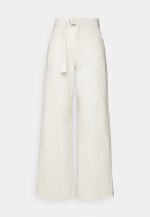 Højtaljede vide cremebukser med forlommer og et matchende stofbælte med en metal ringespænde.