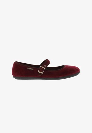 Scarpa piatta Mary Jane in velluto bordeaux con suola nera e cinturino con fibbia argento su sfondo bianco.