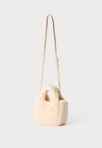Beige faux fur veske med rund topphåndtak og avtagbar reim. Har en myk tekstur og en kompakt rektangulær form.