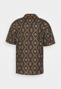 Chemise à manches courtes avec un motif géométrique en losanges vert olive, noir, rouille et blanc et un col classique vue de dos.