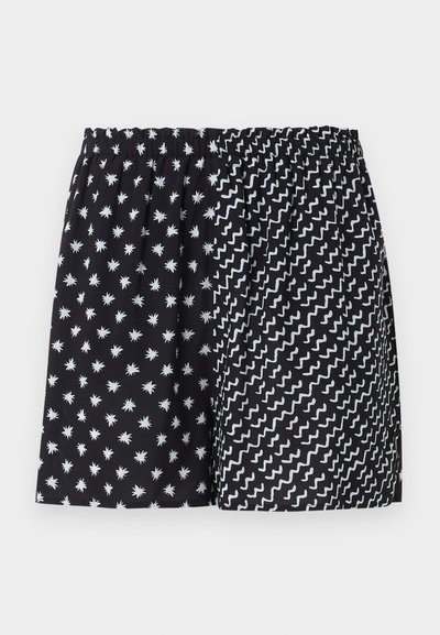 Μαύρα σορτς με ελαστική μέση και δύο σχέδια: άσπρα αστραφτερά μοτίβα αριστερά και άσπρες ζικ-ζακ γραμμές δεξιά.