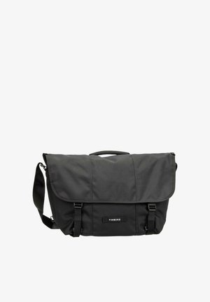 Schwarze Nylon-Umhängetasche mit Klappe, zwei Schnallenriemen, verstellbarem Schultergurt und „TIMBUK2“-Logoaufnäher vorne in der Mitte.