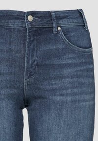 Donker gewaste jeans met een aansluitend ontwerp, gemaakt van denim. Kenmerken zijn een voorzak, rits en metalen knoopsluiting.