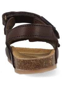 Bruin leren sandaal met verstelbare band, platte kurken voetbed, zichtbare stiksels en rubberen loopzool. Achteraanzicht benadrukt het ontwerp van de band.