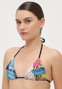 Haut de bikini triangulaire avec des bretelles noires, des motifs multicolores avec des accents bleus, roses et jaunes, et une finition en tissu texturé.