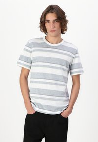 T-shirt rayé présentant des bandes horizontales grises et blanches avec des accents jaunes, col rond, manches courtes, réalisé en tissu texturé.